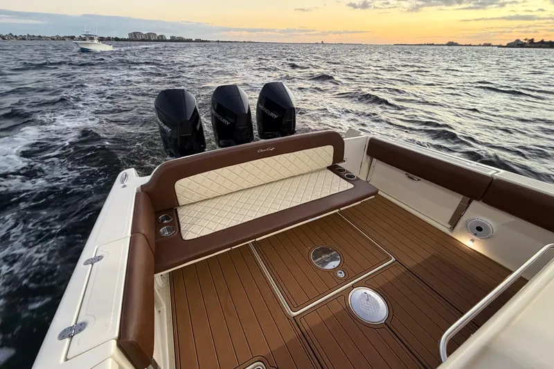 Slide: The Image of 2021 Chris-Craft Catalina 34 boat with triple Mercury engines on open water at sunset. - 23