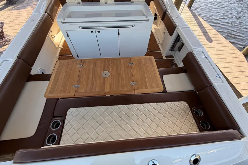 Slide: The Image of 2021 Chris-Craft Catalina 34 interior with wooden table and cushioned seating. - 24