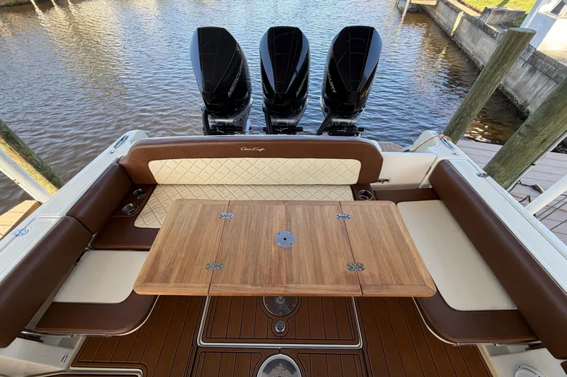 Slide: The Image of 2021 Chris-Craft Catalina 34 boat interior with wooden table and triple Mercury engines. - 25