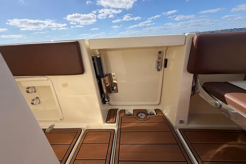 Slide: The Image of 2021 Chris-Craft Catalina 34 boat interior with teak flooring and brown seating under a blue sky. - 26
