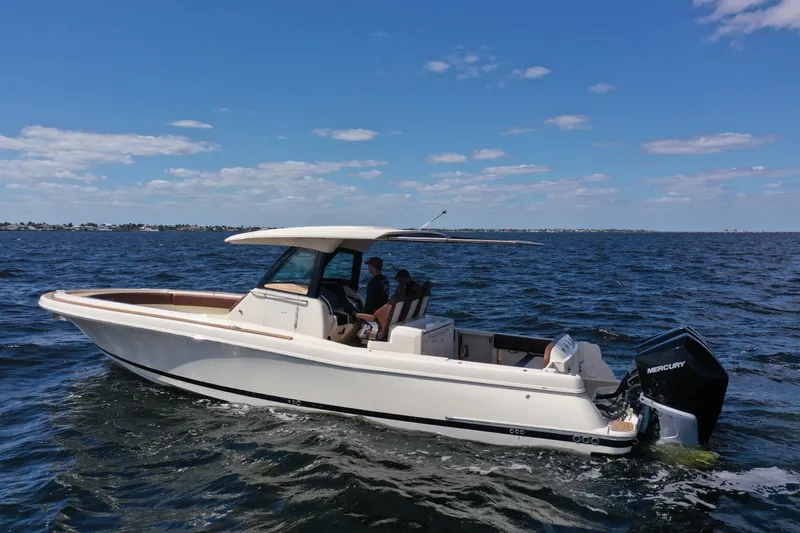 Slide: The Image of 2021 Chris-Craft Catalina 34 boat cruising on open water under a clear blue sky. - 3