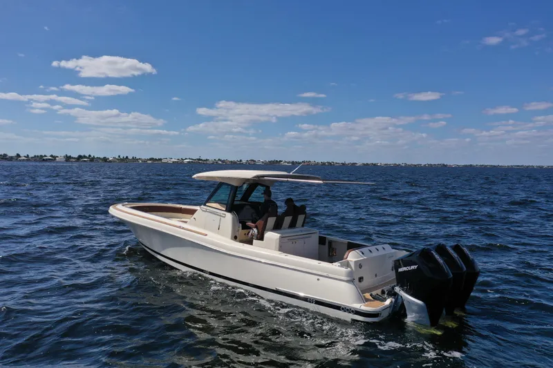 Slide: The Image of 2021 Chris-Craft Catalina 34 boat cruising on open water under a clear blue sky. - 4