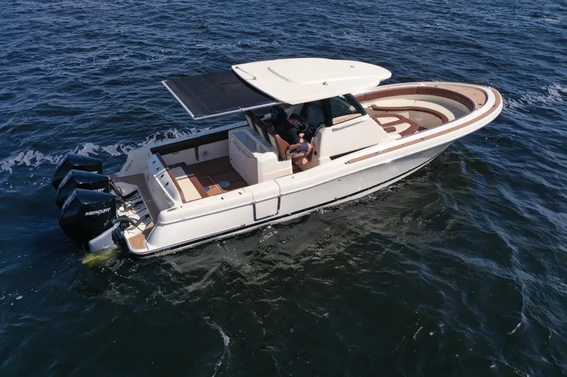 Slide: The Image of 2021 Chris-Craft Catalina 34 boat cruising on open water, featuring triple Mercury engines. - 5