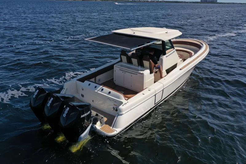 Slide: The Image of 2021 Chris-Craft Catalina 34 cruising on open water with triple Mercury engines. - 6