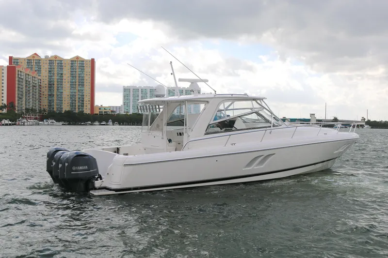 The Image of 2012 Intrepid 475 Sport Yacht on water, cityscape background, Yamaha engines visible. - 0