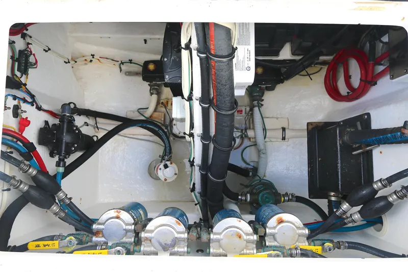 Slide: The Image of Engine compartment of a 2012 Intrepid 475 Sport Yacht, showcasing hoses and mechanical components. - 19