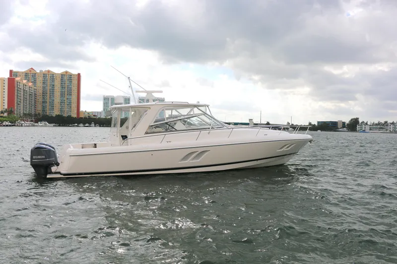 Slide: The Image of 2012 Intrepid 475 Sport Yacht on water with cityscape background. - 23
