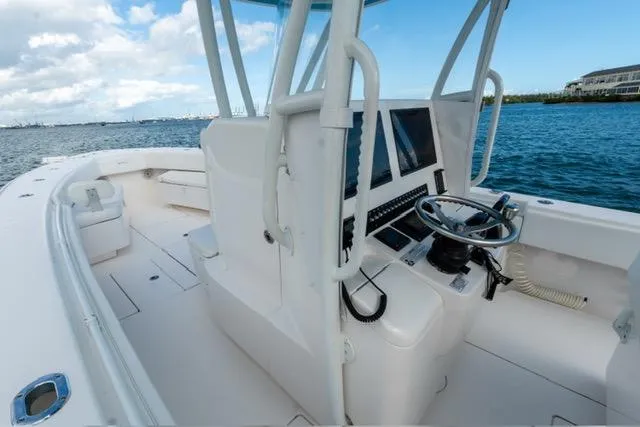 Slide: The Image of 2019 Contender 32 ST boat interior with helm, ocean view, and clear sky. - 10
