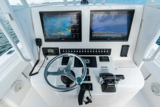 Slide: The Image of 2019 Contender 32 ST boat dashboard with dual navigation screens and controls. - 12