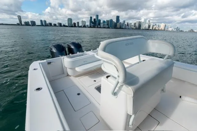Slide: The Image of 2019 Contender 32 ST boat with city skyline in the background on a cloudy day. - 15