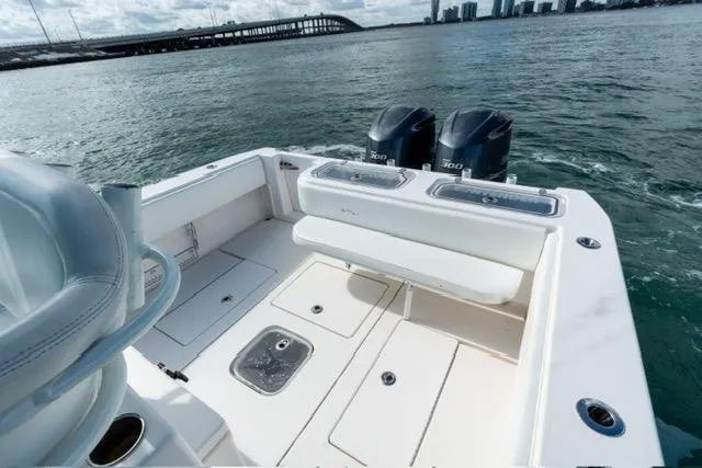 Slide: The Image of 2019 Contender 32 ST boat with dual engines on open water near a bridge. - 16