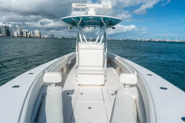 Slide: The Image of 2019 Contender 32 ST boat on water, city skyline in background, clear sky. - 17