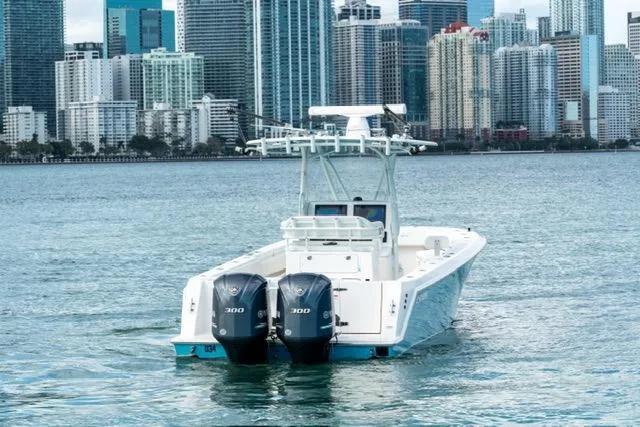 Slide: The Image of 2019 Contender 32 ST boat with twin engines, cruising near a city skyline. - 3