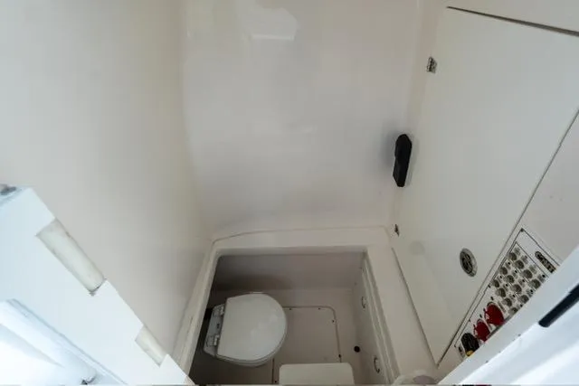 Slide: The Image of 2019 Contender 32 ST boat interior with compact marine toilet and control panel. - 8