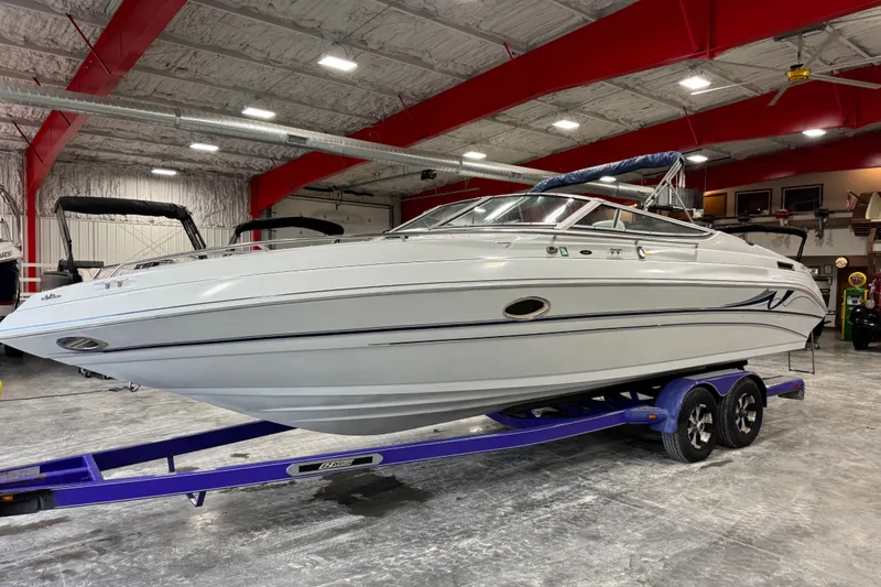 The Image of 1998 Mariah 272 Shabah boat on a trailer in a spacious indoor facility. - 1