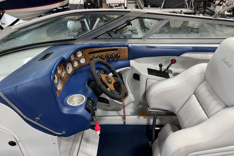 Slide: The Image of 1998 Mariah 272 Shabah boat interior with blue dashboard and white seating. - 8