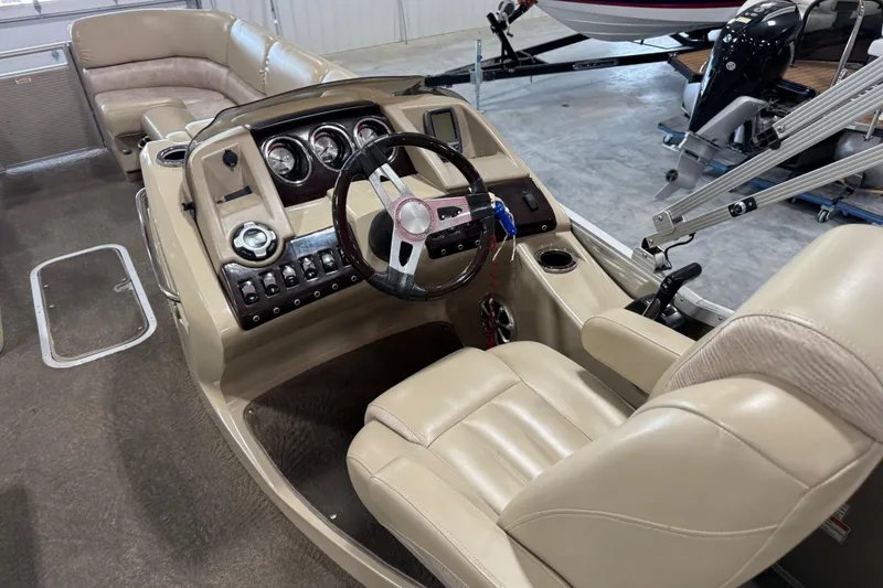 Slide: The Image of Interior of a 2012 Bennington 25 QCW boat with beige leather seating and control panel. - 10