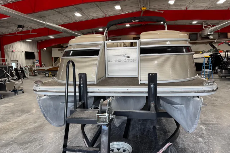 Slide: The Image of 2012 Bennington 25 QCW pontoon boat in a showroom, showcasing sleek design and craftsmanship. - 6