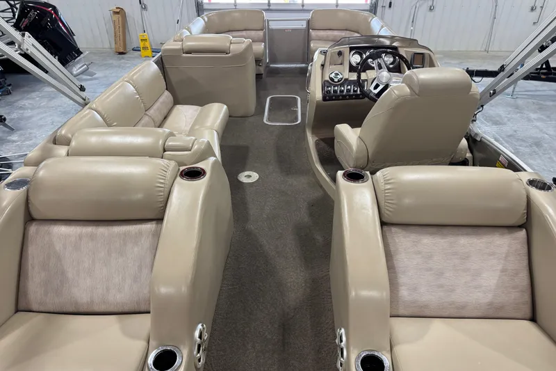 Slide: The Image of Interior of a 2012 Bennington 25 QCW pontoon boat with beige seating and steering console. - 9