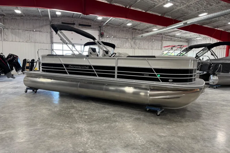 Slide: The Image of 2026 Berkshire 24 RFX LE pontoon boat displayed in a spacious indoor showroom. - 2