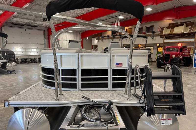 Slide: The Image of 2026 Berkshire 24 RFX LE pontoon boat in showroom, rear view with ladder and seating. - 4