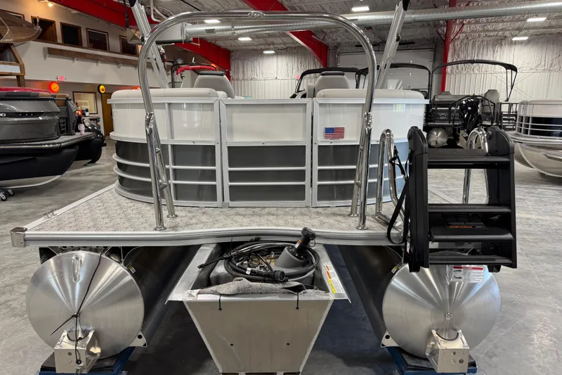 Slide: The Image of 2026 Berkshire 24RFX LE pontoon boat in showroom, rear view with ladder and American flag. - 5