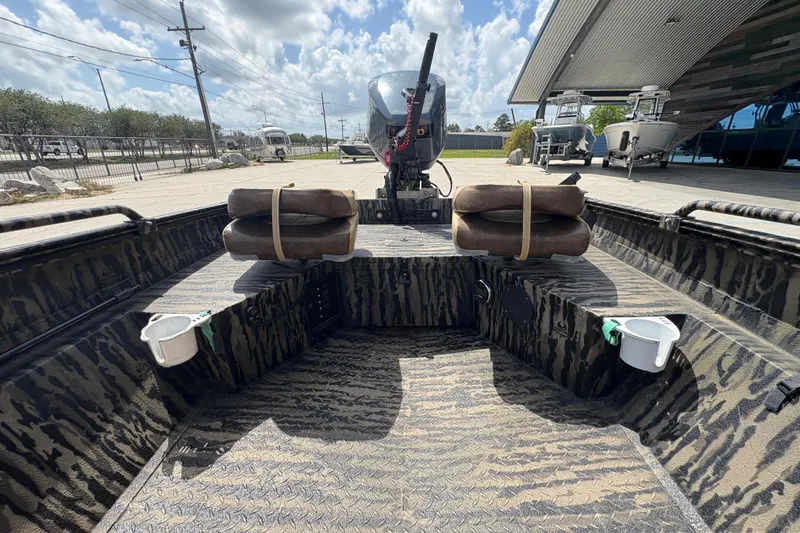 Slide: The Image of 2022 Edge Duck Boats HPSD 1656DB interior with camo design and motor, under a cloudy sky. - 14