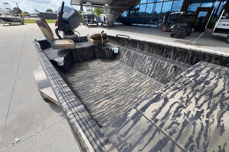 Slide: The Image of 2022 Edge Duck Boats HPSD 1656DB with camouflage interior, parked outdoors. - 20