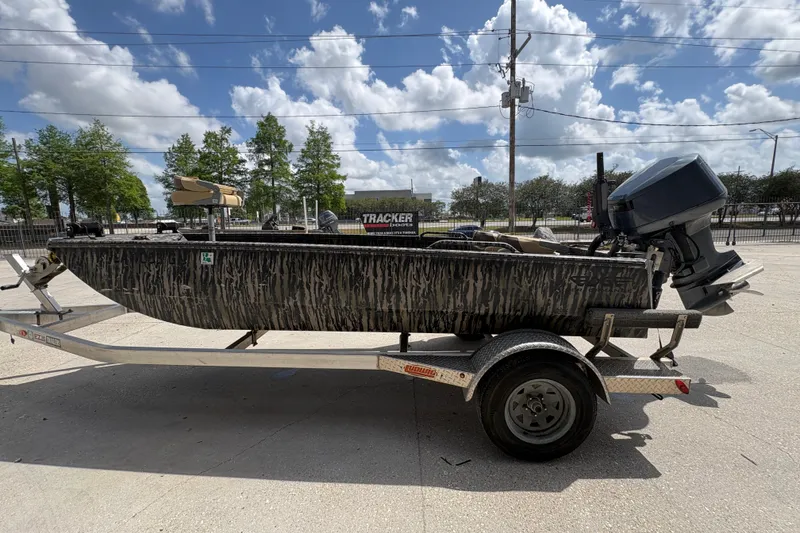 Slide: The Image of 2022 Edge Duck Boats HPSD 1656DB on trailer, camo design, outboard motor, sunny day. - 6