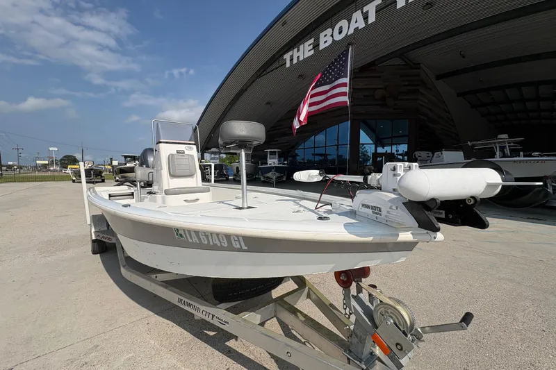 Slide: The Image of 2021 Avid 21 FS boat on trailer outside dealership, American flag displayed. - 10