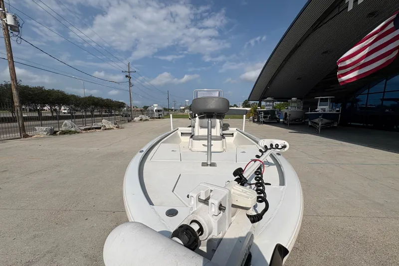 Slide: The Image of 2021 Avid 21 FS boat parked outdoors with American flag and clear sky. - 11