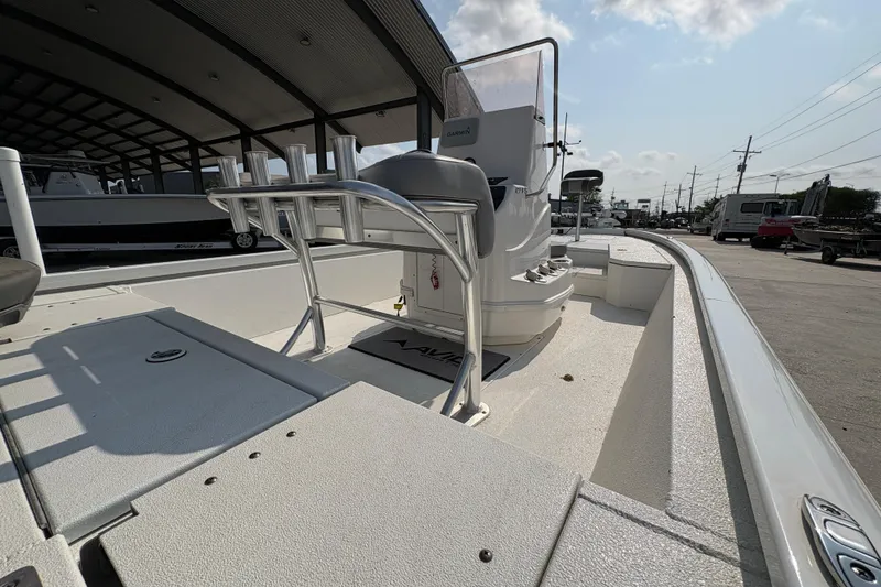 Slide: The Image of 2021 Avid 21 FS boat interior with console and rod holders under a covered area. - 14
