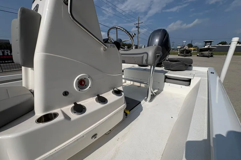 Slide: The Image of 2021 Avid 21 FS boat interior with steering console and seating under clear sky. - 16