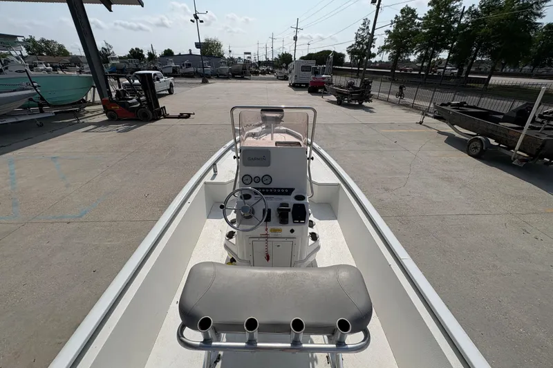 Slide: The Image of 2021 Avid 21 FS boat interior with steering console and seating in a marina setting. - 19