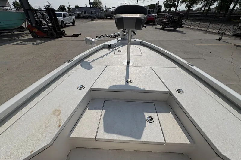 Slide: The Image of 2021 Avid 21 FS boat deck with seating and storage compartments in a marina setting. - 21