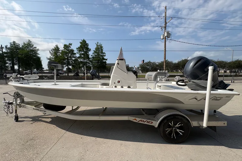 Slide: The Image of 2021 Avid 21 FS boat on trailer, parked outdoors under a clear sky. - 7