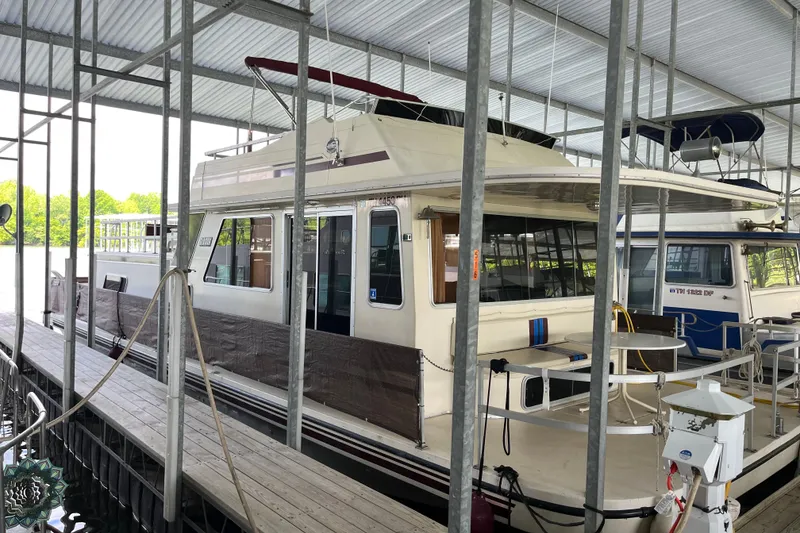 The Image of 1990 Gibson 44 houseboat docked in a covered marina. - 0