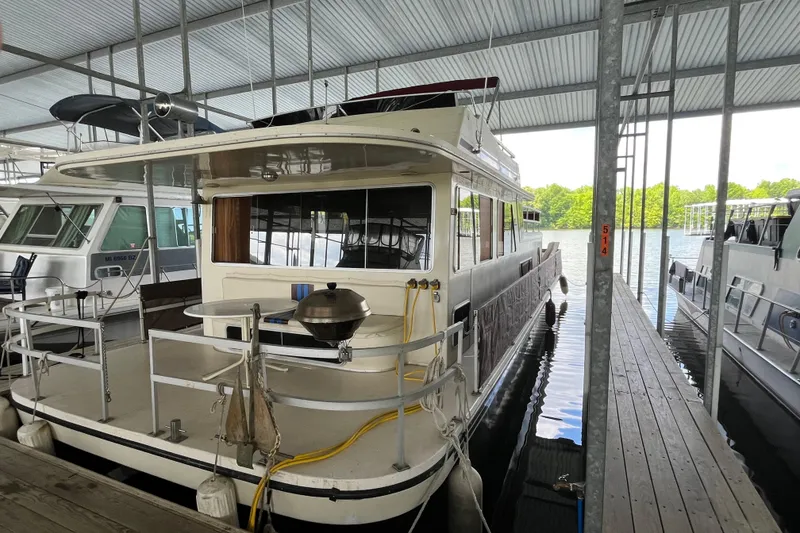 Slide: The Image of Houseboat docked in marina, Gibson model 44, 1990, with covered deck and outdoor grill. - 1