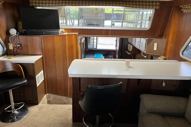 Slide: The Image of Interior of a 1990 Gibson 44 boat with wood paneling and modern amenities. - 12