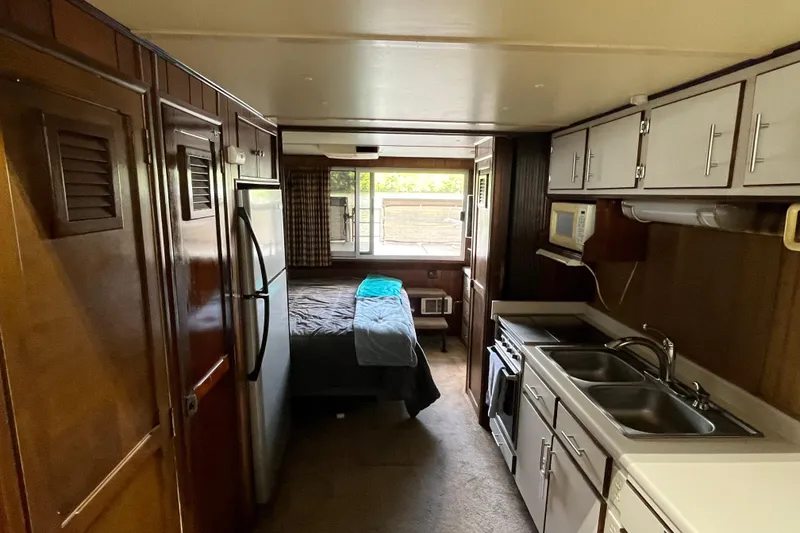 Slide: The Image of Interior of a 1990 Gibson 44 boat with kitchen and bedroom area. - 14