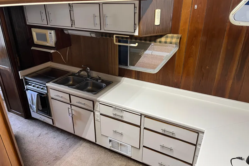 Slide: The Image of Vintage 1990 Gibson model 44 kitchen with wood paneling, dual sink, and microwave. - 15