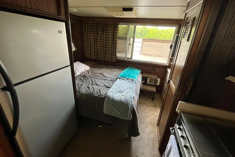 Slide: The Image of Cozy bedroom in a 1990 Gibson 44 boat with a window view. - 18