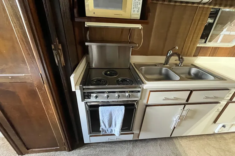 Slide: The Image of Compact kitchen with stove, microwave, and double sink in a 1990 Gibson model 44. - 20