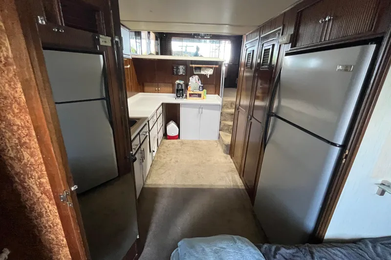 Slide: The Image of Interior of a 1990 Gibson 44 boat kitchen with appliances and wooden cabinetry. - 21