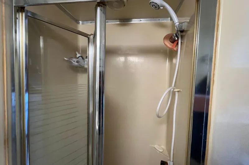 Slide: The Image of 1990 Gibson 44 shower with chrome fixtures and handheld showerhead. - 24