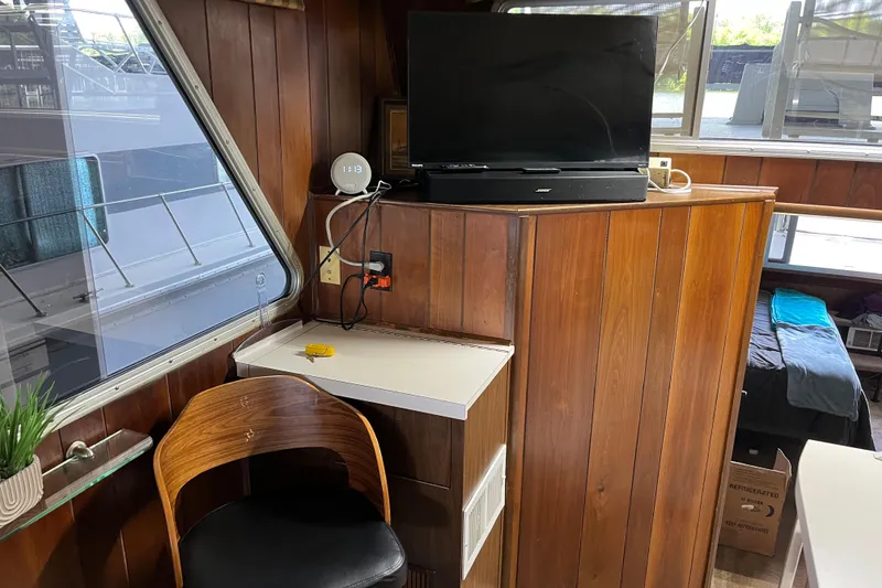 Slide: The Image of 1990 Gibson 44 interior with wood paneling, TV, and seating area. - 26