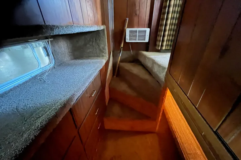 Slide: The Image of Interior of a 1990 Gibson 44 boat with wood paneling and carpeted surfaces. - 27