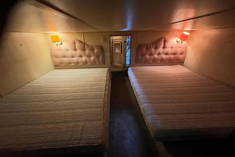 Slide: The Image of Cozy cabin interior with twin beds, tufted headboards, and warm lighting in a 1990 Gibson 44. - 28