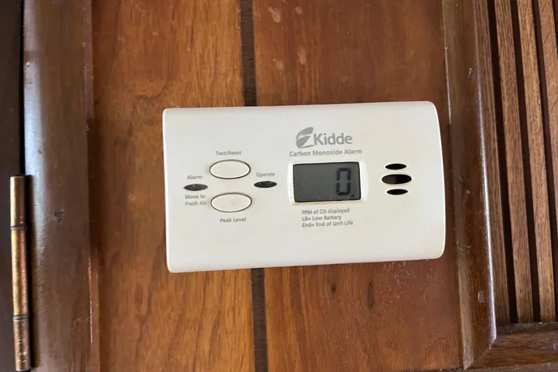 Slide: The Image of Kidde carbon monoxide alarm displaying zero, mounted on a wooden surface. - 32