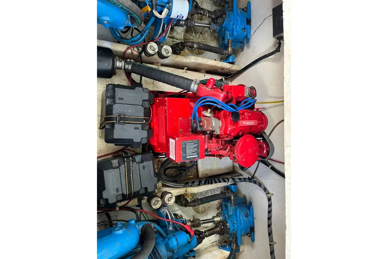 Slide: The Image of Engine compartment of a 1990 Gibson 44 boat, featuring a red engine and blue components. - 36